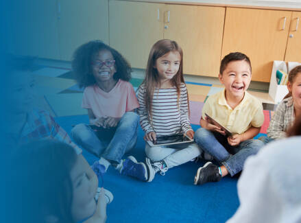 early childhood students in circle looking up at their teacher